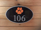 Oval house number sign with number 106 and paw print