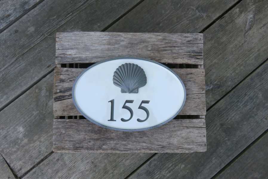 House number sign with 155 and 3D scallop shell carved on it
