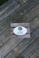 Oval house number sign with 155 and 3D scallop shell carved on it
