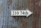 arrow sign pointing right with address carved on it painted white and black