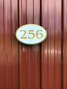 256 white and gold oval house number sign