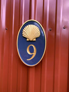 Oval house number with realistic shell painted naval blue and gold with number 9