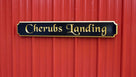 Cherubs Landing wording carved on quarterboard painted black and gold