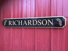 Last name Richardson carved on black and gold quarterboard with olive branches