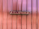 Red and gold quarterboard sign hanging on barn