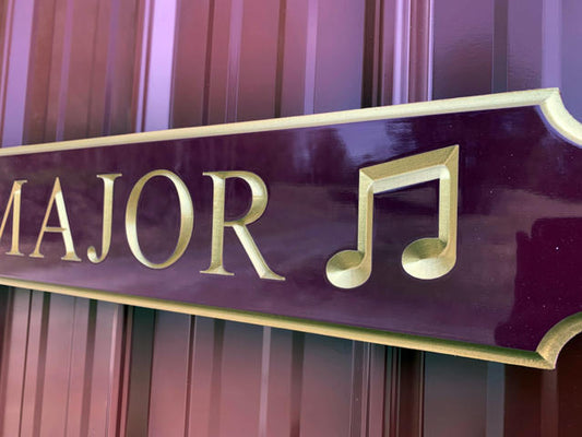 Close up of Quaterboard sign with Sea Major carved on it with musical notes