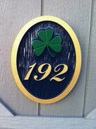3 digit house number with fancy font and green shamrock easy to read black and gold color scheme