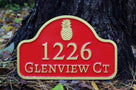 arched top house address sign with pineapple painted maroon and gold