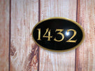 1432 black and gold oval house number sign