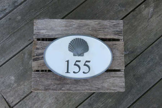 House number sign with 155 and 3D scallop shell carved on it