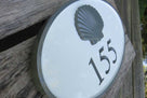 House number sign with 155 and 3D scallop shell carved on it painted white and gray.