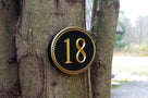 House number with rope border painted black and gold.