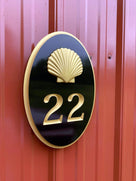 Custom carved house number sign painted black and gold with 22