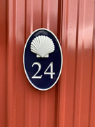 Oval house number with silver realistic shell and number 24 painted black and silver