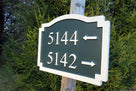 Side view of multiple address number sign with directional arrows