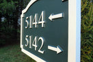 Close up view of multiple address number sign with directional arrows