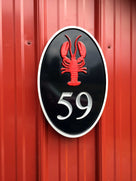 oval vertical house number with 59 and lobster carved on it