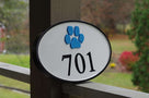 Horizontal oval with 701 house number sign and paw print carved on it