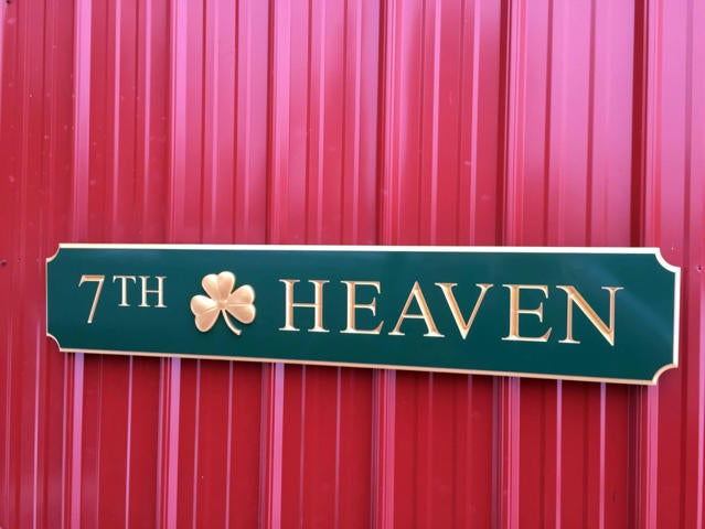 Green and gold quarterboard sign with 7th Heaven carved on it and 3D shamrock
