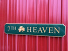 Green and gold quarterboard sign with 7th Heaven carved on it and 3D shamrock