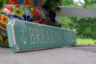 Side view of Breaking Wind quarterboard sign painted sea foam green and white