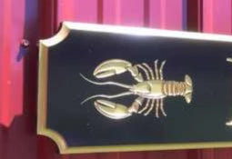 Angle view of Custom carved quarterboard with Eden Pointe and lobster carved on it