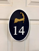 Vertical oval house number sign with 14 and Cape Cod boundary carved on it
