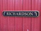 Custom quarterboard with last name Richardson and olive branch carved on it painted black and gold