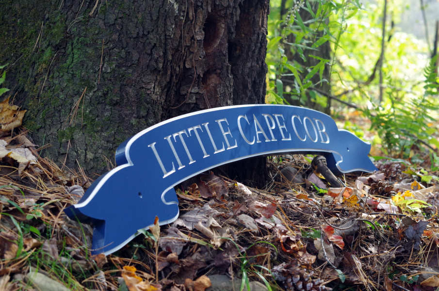 Side view of banner style quarterboard painted blue and silver saying Little Cape Cob