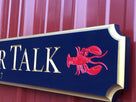 Close of up lobster carved on quarterboard sign