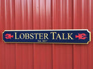 quarterboard sign with lobsters and Lobster Talk wording carved on it