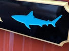 Quarterboard with McT by the Sea carved on it and close up picture of shark on sign
