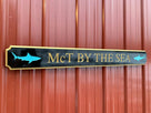 Quarterboard with McT by the Sea and shark images carved on it