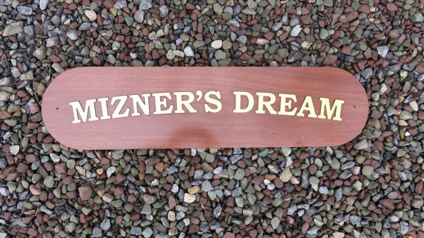 Mahogany quarterboard with Mizner's Dream carved on it in gold