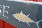 Close up of shark carved on Quarterboard sign with Safe House carved on it