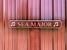Quaterboard sign with Sea Major carved on it with musical notes painted burgundy and gold