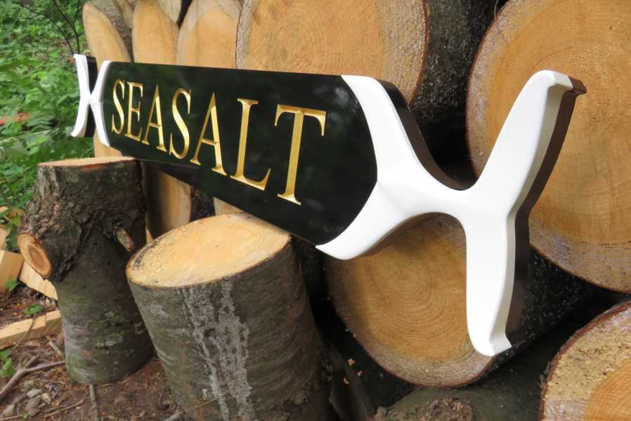 Side view of custom carved exterior quarterboard with whale tail ends