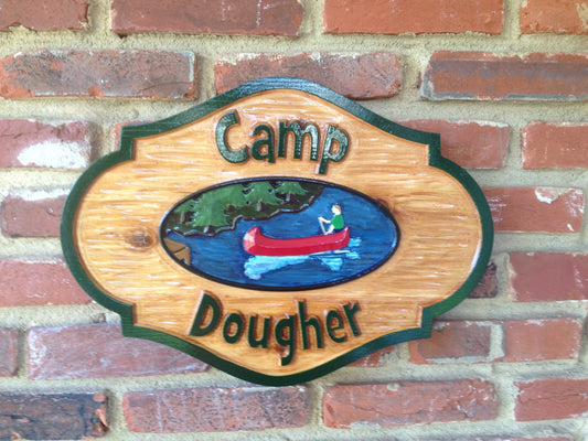 Rustic cedar carved camp sign with last name and canoe on lake image