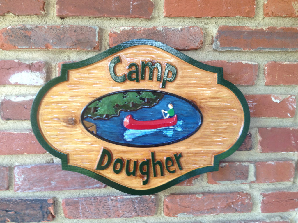 Rustic cedar carved camp sign with last name and canoe on lake image
