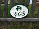 carved house number sign with shamrock painted white and green