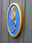 Bright blue and gold house number sign