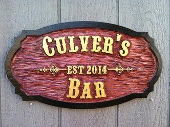 Carved cedar bar sign with western theme font and established date