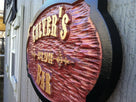 Old west themed cedar bar sign with stained background and gold letters