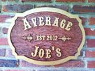 Carved oak bar sign wit wild west font is stained personalized with name and established date