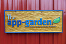 Small business sign carved from cedar wood with the app garden carved on it with light stain background