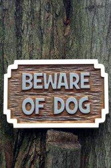 Beware of dog sign in carved cedar front view