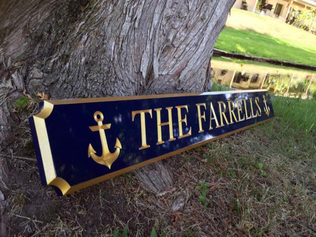 Quarterboard custom made with The Farrells carved on it painted blue and gold