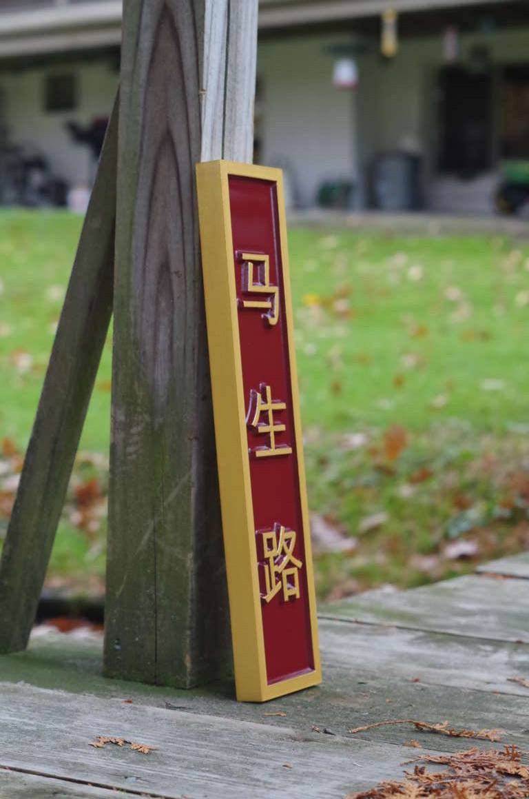 Side view of Custom sign with Chinese characters painted red and gold