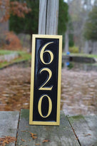 620 house number sign in vertical position painted black and gold