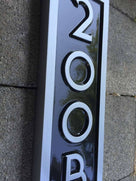 Vertical house number sign with letter
